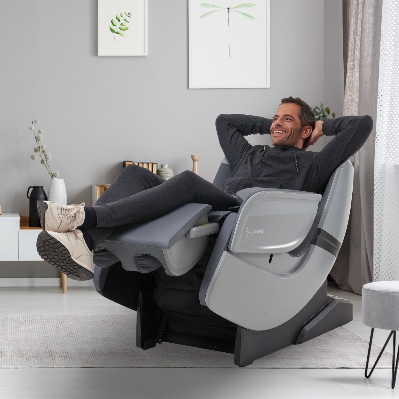 Mann liegend mit Schuhen im Massagesessel Casada Ecosonic - Silber im Wohnzimmer