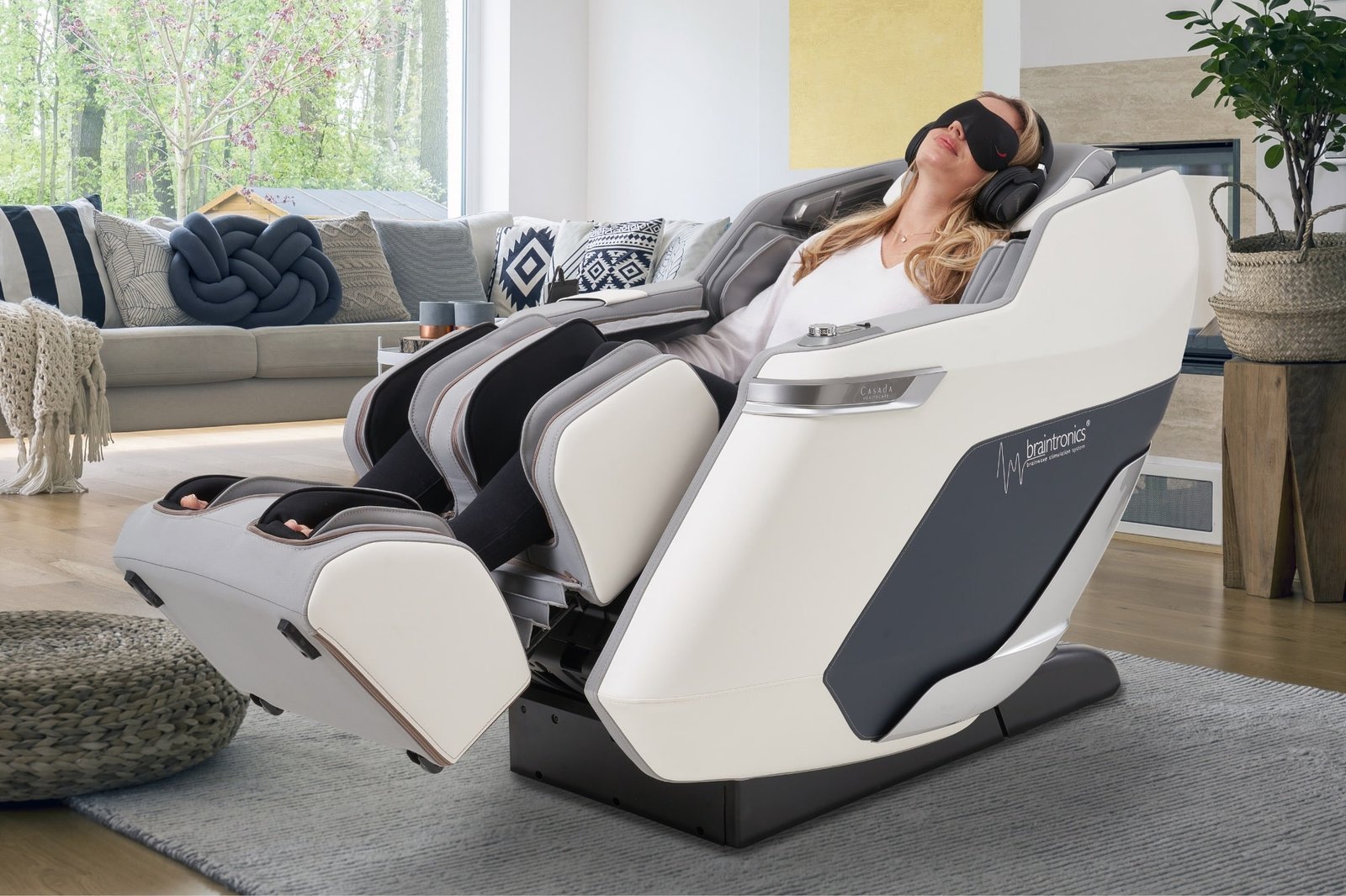 femme dans un fauteuil de massage Casada pollux blanc avec un casque braintronics