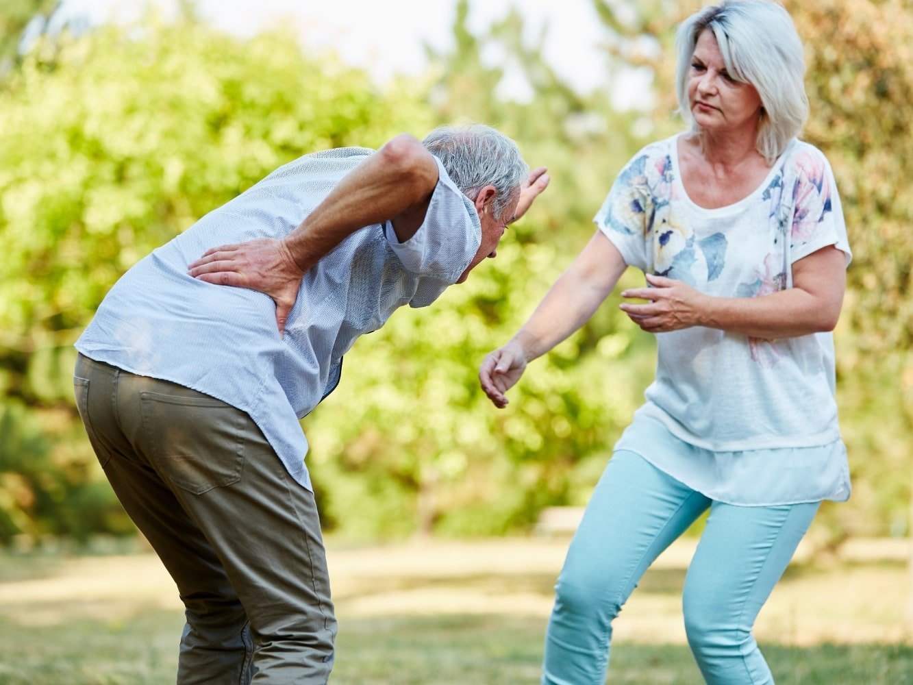 Woman helping man with lumbago symptoms