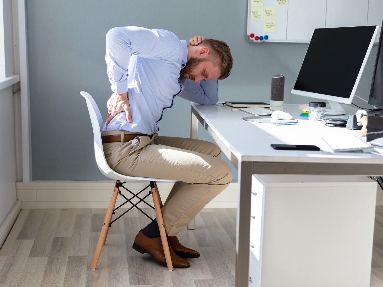 man in office at desk with sore back